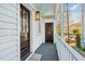 Long front porch with white railings, dark grey flooring, and a view of the street at 17 H St, Charleston, SC 29403