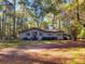 Cozy ranch home surrounded by lush greenery and tall trees at 400 Murray Blvd, Summerville, SC 29483