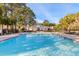 Inviting community pool with a spacious deck and surrounding landscaping at 1025 Riverland Woods Pl # 208, Charleston, SC 29412