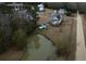 White farmhouse with pond and surrounding landscape; other homes visible in distance at 1104 Hitchfield Ln, Awendaw, SC 29429