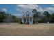 House with wrap-around porch, American flag, and spacious yard at 1104 Hitchfield Ln, Awendaw, SC 29429