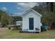 White storage shed with black door in backyard setting at 1104 Hitchfield Ln, Awendaw, SC 29429