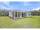 A backyard featuring a screened-in porch and ample space for outdoor activities on the grassy lawn at 1149 Reserve Ln, Awendaw, SC 29429