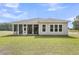 Backyard view of home featuring a screened-in porch and a spacious lawn with wooded surroundings at 1149 Reserve Ln, Awendaw, SC 29429