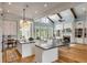 Open concept kitchen features large island, white cabinets, and hardwood floors at 1484 Old Rosebud Trl, Awendaw, SC 29429