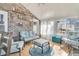 Bright sunroom with seating area, wood floors, and brick wall at 211 Brailsford Rd, Summerville, SC 29485