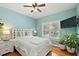 Cozy bedroom with hardwood floors, a ceiling fan, and a mounted TV at 2212 Salt Wind Way, Mount Pleasant, SC 29466