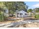 Charming white house with black shutters, a porch, and a landscaped yard at 2720 W Surrey Dr, North Charleston, SC 29405