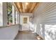A long, narrow front porch with whitewashed wood ceiling and white door at 2720 W Surrey Dr, North Charleston, SC 29405
