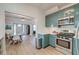 Modern kitchen with teal cabinets, stainless steel appliances, and white countertops at 33 Cypress St, Charleston, SC 29403