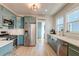 Modern kitchen with teal cabinets, stainless steel appliances, and white countertops at 33 Cypress St, Charleston, SC 29403