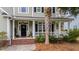 Inviting front porch with black door, white columns, and potted plants at 113 History Ln, Summerville, SC 29485