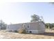 Rear view of a gray manufactured home with wooden steps and AC unit at 126 Wilder Rd, Saint Stephen, SC 29479