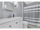 Clean bathroom with white vanity, gray shiplap walls, and striped shower curtain at 1300 Park West Blvd # 417, Mount Pleasant, SC 29466