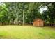 Large backyard with wooden shed, fenced in area and trees at 1733 Main Rd, Johns Island, SC 29455