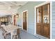 Outdoor dining area on a spacious porch with multiple doors leading to the house at 2256 Ion Ave, Sullivans Island, SC 29482