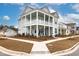 Two-story light teal house with white accents, front porch, and landscaped yard at 229 Symphony Ave, Summerville, SC 29486