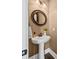Elegant powder room with pedestal sink and round mirror at 3913 Maidstone Dr, Mount Pleasant, SC 29466
