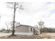 Side view of a tan manufactured home with black windows and wooden steps at 520 Branch Bend Way, Cross, SC 29436