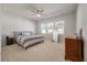 Spacious primary bedroom with carpeted floor, ceiling fan and large windows at 556 Mclernon Trce, Johns Island, SC 29455