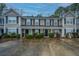 Tan two-story townhome with black shutters and a shared driveway at 8875 Jenny Lind St, North Charleston, SC 29406