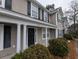 Two-story tan house with white columns, black door, and landscaping at 8875 Jenny Lind St, North Charleston, SC 29406