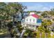 Two-story white house with red roof, surrounded by lush greenery and trees at 1086 Cinder St, Mount Pleasant, SC 29464