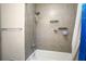 Clean bathroom featuring a shower/tub combo, tile surround, and storage shelves at 115 Three Wood Ln, Summerville, SC 29483