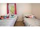 Two twin beds with colorful bedding and stuffed animals, window with pink curtains at 115 Three Wood Ln, Summerville, SC 29483