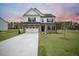Two-story home with white siding, brick accents, and a large driveway at 117 Arabian Drive Lot B, Summerville, SC 29483