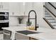 Modern kitchen island with farmhouse sink, quartz countertop, and black faucet at 117 Arabian Drive Lot B, Summerville, SC 29483