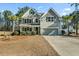 Two-story house with gray siding, a large driveway, and landscaping at 123 Beam St, Huger, SC 29450