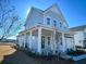 Two-story farmhouse with gray siding, metal roof, and front porch at 1573 Trailmore Ln, Summerville, SC 29486