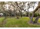 Landscaped backyard with mature trees and a birdhouse at 1860 Headquarters Plantation Dr, Johns Island, SC 29455