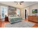Comfortable bedroom with a rustic headboard, green bedding, and hardwood floors at 1860 Headquarters Plantation Dr, Johns Island, SC 29455