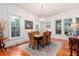 Bright dining room features a rustic wooden table and wicker chairs, hardwood floors, and large windows at 1860 Headquarters Plantation Dr, Johns Island, SC 29455