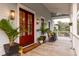 Front porch with red door, plants, and rocking chairs at 1860 Headquarters Plantation Dr, Johns Island, SC 29455