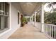 Long front porch with rocking chairs, ceiling fan, and view of trees at 1860 Headquarters Plantation Dr, Johns Island, SC 29455