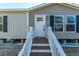 Front entrance with white door and wooden stairs at 240 Carolina Dr, Saint Stephen, SC 29479