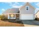 Gray house with a white garage door, porch, and landscaping at 3026 Gulfstream Ln, Ridgeville, SC 29472