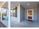 Covered porch with columns, red door, and blue chair at 3026 Gulfstream Ln, Ridgeville, SC 29472
