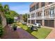 Private backyard with artificial turf, brick pathways, and seating areas at 38 Hasell St, Charleston, SC 29401