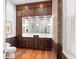 Bathroom with double vanity, marble countertop and brick accent at 38 Hasell St, Charleston, SC 29401