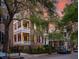 Historic brick home with white columns and balconies at sunset at 38 Hasell St, Charleston, SC 29401