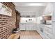 White kitchen features exposed brick, ample counter space, and modern appliances at 38 Hasell St, Charleston, SC 29401