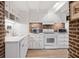 Bright kitchen with white cabinets and exposed brick wall at 38 Hasell St, Charleston, SC 29401