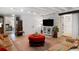 Comfortable living room with exposed brick, red ottoman, and ample seating at 38 Hasell St, Charleston, SC 29401