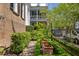 Landscaped side yard with lush greenery and brick pathways at 38 Hasell St, Charleston, SC 29401