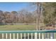 Open backyard view from deck, showcasing trees and fence at 3980 River Rd, Johns Island, SC 29455