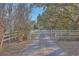 Long driveway leading to a home with white fences and mature trees at 3980 River Rd, Johns Island, SC 29455